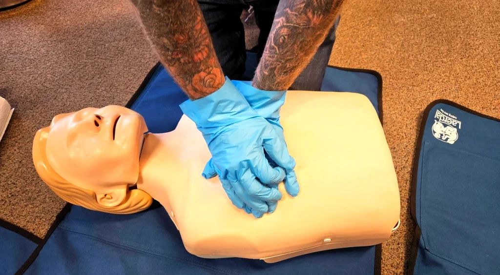 First aid training Lowestoft – CPR chest compressions practice during on-site workplace first aid course
